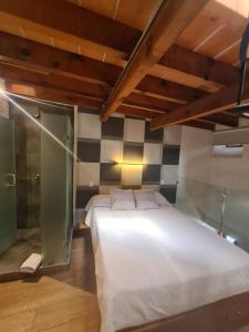 Un dormitorio con una gran cama blanca en una habitación. en Loft 41 by Casa Matia, en San Miguel de Allende