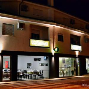 ヴィダゴにあるRestaurante e Residencial O Resineiroのテーブルと椅子のあるレストランを併設する建物