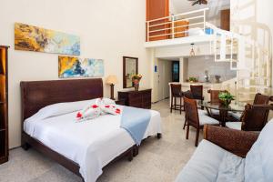 een slaapkamer met een bed en een eetkamer bij 2 Story Oceanfront Penthouses on Cancun Beach! in Cancun +53 foto's