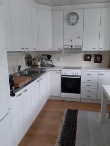 una cucina bianca con armadi bianchi e lavandino di Peltorinne 14 a Savonlinna