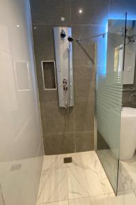 a bathroom with a glass shower with a toilet at Residence INFINITE in Dakar