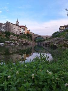 un pont sur une rivière avec des bâtiments et des fleurs dans l'établissement Apartma Kanal, à Kanal