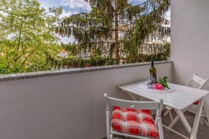 a white table and chairs on a balcony with a window at New two bedroom apartment Maloni in Pula