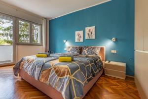 a bedroom with blue walls and a bed with yellow pillows at New two bedroom apartment Maloni in Pula
