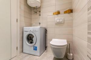a bathroom with a washing machine and a toilet at New two bedroom apartment Maloni in Pula