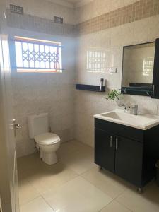 a bathroom with a toilet and a sink at Samkab Legacy & comfort Ndeke (airport) in Lusaka