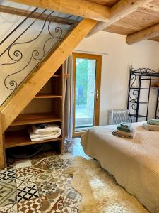 a bedroom with a bed and a staircase in a room at La Source in Rustrel
