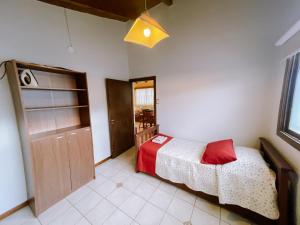 Un dormitorio con una cama con una almohada roja. en Casa Roca en Ushuaia