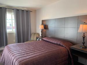 a hotel room with a bed and a window at Winsome Inn in Saint Stephen