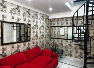 a living room with a red couch and a staircase at Malecon Rooms y Hotel in Santo Domingo