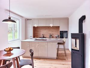 a kitchen with white cabinets and a table and chairs at Top Ferienhaus bei Spitz / Wachau in Schwallenbach