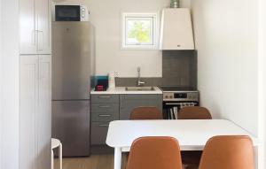 una pequeña cocina con mesa blanca y sillas en 2 Bedroom Awesome Home In Gotlands Tofta, en Västergarn
