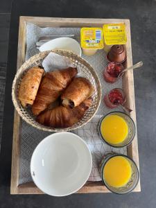 a tray with two baskets of bread and orange juice at Magnifique loveroom in Marseille