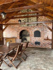 a patio with a table and chairs and a brick fireplace at Jaskółcze Gniazdo 