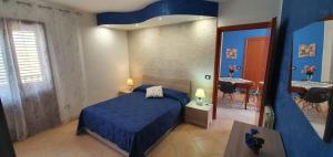 a bedroom with a blue bed and a dining room at Casa Vacanze Maniscalco Sciacca in Sciacca