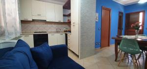 a living room with a blue couch and a kitchen at Casa Vacanze Maniscalco Sciacca in Sciacca