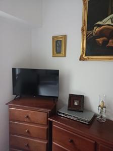 1 dormitorio con TV y vestidor con ordenador portátil en Shvili en Buenos Aires