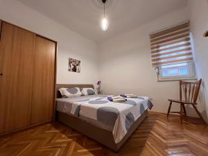 a bedroom with a bed and a wooden floor at DALIA Apartment & Room in Mostar
