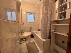 a bathroom with a sink and a toilet and a tub at DALIA Apartment & Room in Mostar