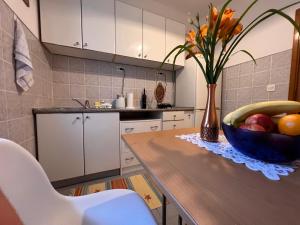 a kitchen with a wooden table with a bowl of fruit at DALIA Apartment & Room in Mostar
