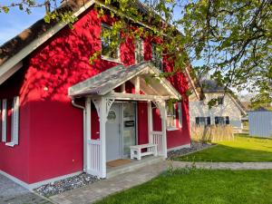 una casa rossa con una panchina davanti di Villa-Holzreich a Lohme