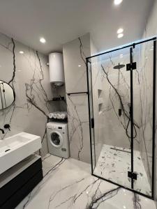 a bathroom with a shower and a washing machine at Tirana LUX Apartments in Tirana