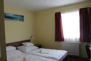 een hotelkamer met 2 bedden en een raam bij Pótkerék Motel in Győr