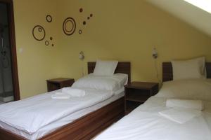 two beds sitting next to each other in a room at Pótkerék Motel in Győr