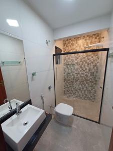 La salle de bains est pourvue de toilettes, d'une douche et d'un lavabo. dans l'établissement Pousada São João, à São Thomé das Letras