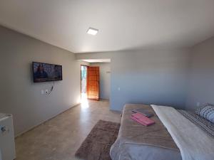 サン・トメー・ダス・レトラスにあるPousada São Joãoのベッドルーム1室(ピンクのアイテムが入ったベッド1台付)