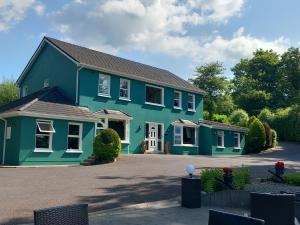 una casa azul y verde con entrada en Watersedge Seaviews en Kenmare