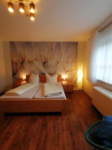 1 dormitorio con 1 cama con una pintura en la pared en Ferienhaus Am Sommerberg, en Gießübel