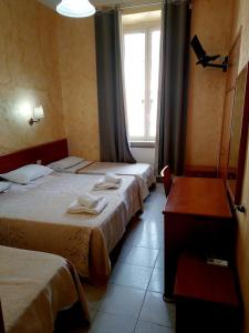 a hotel room with two beds and a window at Hotel Ferrari in Rome