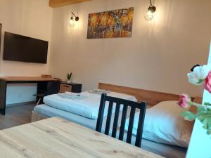 a hotel room with two beds and a desk at Apartmány Lucie in Jihlava