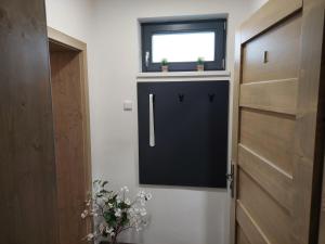 a bathroom with a black door and a window at Apartmány Lucie in Jihlava