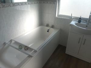 a white bathroom with a tub and a sink at Sawel view Apartments in Dungiven