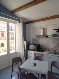 a kitchen with a white table and chairs and a counter at LA REGGIA APARTMENTS MILAZZO in Milazzo