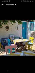 einen Picknicktisch und Stühle auf einer Terrasse mit blauer Tür in der Unterkunft Güneş Butik Otel Datça in Cumalı