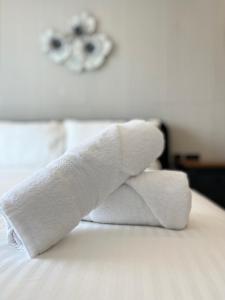 a stack of towels sitting on top of a bed at Msida Marina Apartments in Msida