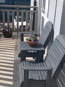 a wooden table and bench with a bowl of flowers on it at Sawel view Apartments in Dungiven