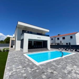 dom z basenem przed domem w obiekcie Villa Mila w mieście Vrsi