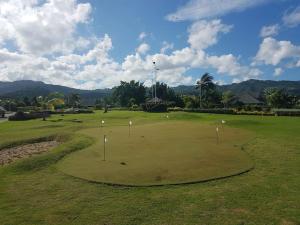 a golf course with a hole in the grass at Richmond - Heroes Villa, North Coast, Gated, Access to Swimming Pool, Playground & Private Beach - Welcome Basket in Richmond