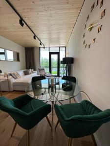 ein Wohnzimmer mit einem Glastisch und grünen Stühlen in der Unterkunft Penati golf by Kate in Šajdíkove Humence