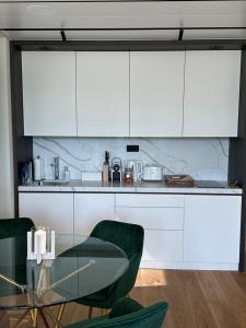 a kitchen with a glass table and white cabinets at Penati golf by Kate in Šajdíkove Humence +2 photos