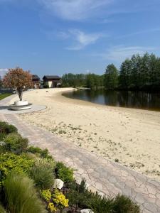 a sandy beach with a tree in the middle of a river at Penati golf by Kate in Šajdíkove Humence