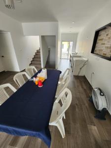 une salle à manger avec une table bleue et des chaises blanches dans l'établissement habitaciones disponibles con baño privado zona centro, à Cunduacán