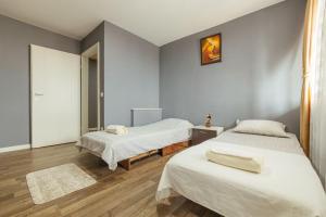 1 Schlafzimmer mit 2 Betten und einem Spiegel in der Unterkunft Flamingo Apartment in Pristina