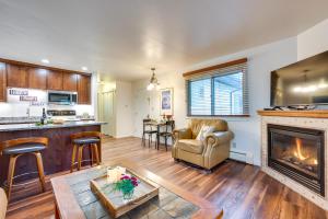 a kitchen and living room with a fireplace and a couch at Estes Park Condo Rental Balcony with River Views! in Estes Park