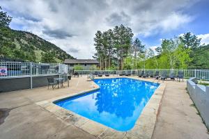 a swimming pool with blue water in a yard at Estes Park Condo Rental Balcony with River Views! in Estes Park