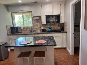 a kitchen with white cabinets and a black counter top at Raymond Haven Ranch bass lake Yosemite in Raymond